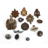 A quantity of military cap badges and buttons for various regiments.