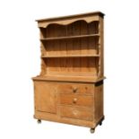 A pine dresser with two-tier plate rack above a cupboard with three drawers and single panel door,