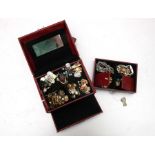 A quantity of costume jewellery, mainly earrings, in a red jewellery box.