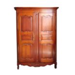 A French fruitwood armoire with two panelled doors above a shaped apron, 140cms wide.