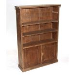 A pine open bookcase with three shelves above a cupboard, on a plinth base, 74cms wide. 106cm high