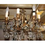 A brass eight-arm electrolier ceiling light with glass drops, 52cms wide.