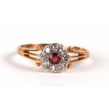 A yellow metal (tests as 18ct) ruby and diamond cluster ring, approx UK size 'Q'.