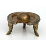 Equestrian interest - a copper, brass and blue enamel horseshoe inkwell with riding boot supports