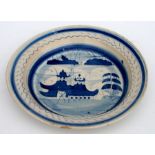 A 19th century Delft blue & white plate decorated with a landscape scene, 27cms diameter.