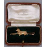 A 9ct gold bar brooch or stock pin with cast figure of a corgi dog, weight 6.5g, cased.