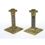 A pair of 19th century brass and polished granite candlesticks, 16cms high (2).
