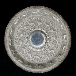 An Indian white metal dish with repousse decoration depicting various animals including elephants,