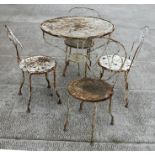 A well weathered French painted matched five-piece patio table and chairs comprising a circular