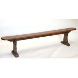 A large elm bench of slender proportions with rounded rectangular top on shaped end supports, 218cms