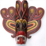 A large hand painted wooden South East Asian mask wall plaque, 77cms high.