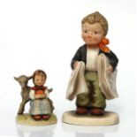 A Goebel group depicting a young girl with a lamb, 9cms high; together with another similar larger