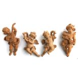 Four Grand Tour style wooden carvings depicting cherubs playing musical instruments, each approx