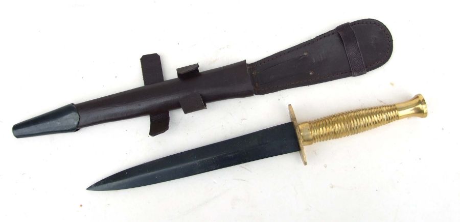 A WW2 style British Commando Knife in its leather scabbard with metal mounts and elasticated loop.