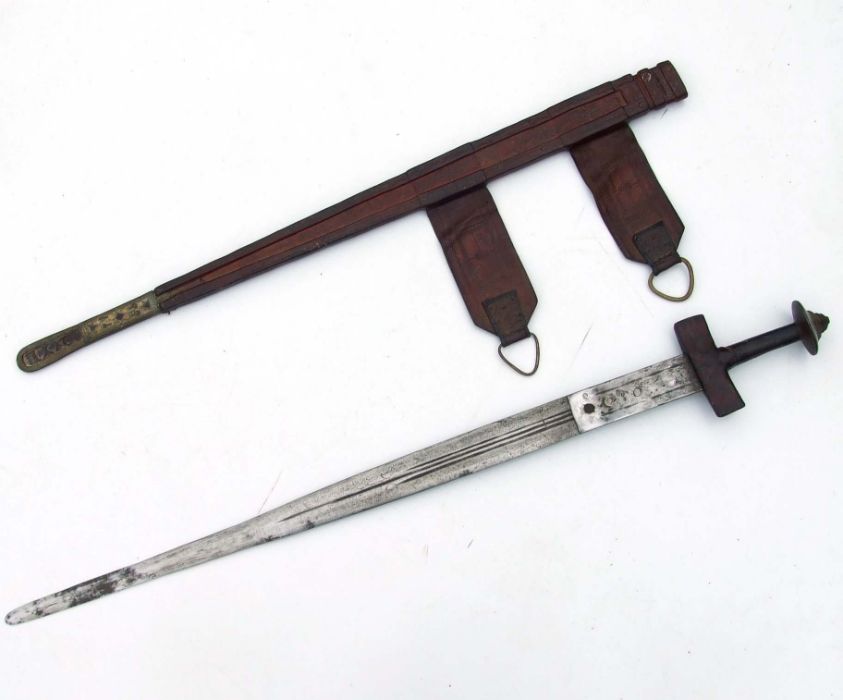 A North African sword in a tooled leather scabbard, 89cms long.