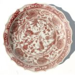 A Chinese underglaze red oxide shallow shaped dish, 23cms diameter.