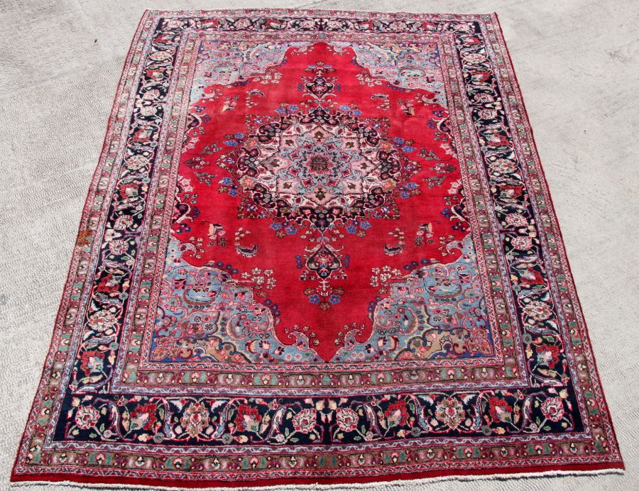 A Persian Meshed hand knotted wool carpet with central foliate design within foliate borders, on a