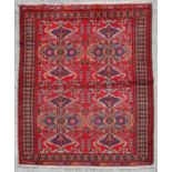 A Persian Gonbad rug with butterfly design within stylised borders, on a red ground, 185 by 130cms.