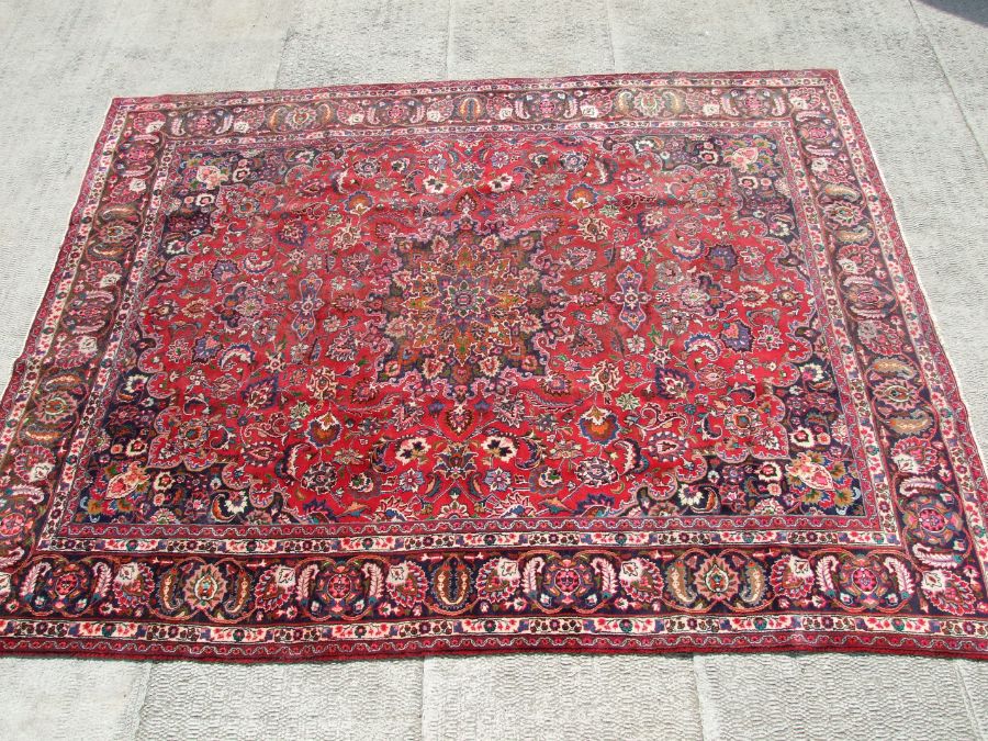 A Persian Mashad woollen hand knotted carpet with central foliate gul within foliate borders, on a - Image 3 of 6