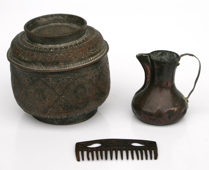 An Indian copper food container with repousse decoration, 16cms diameter; together with a copper jug