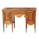 An Edwardian mahogany ladies kneehole desk with a central frieze drawer flanked by cupboards, on