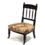 A late 19th century ebonised Godwin style design nursing chair with upholstered seat, on turned