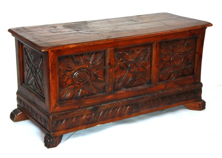 A continental coffer with carved panels above a carved apron, on carved feet, 120cms wide.