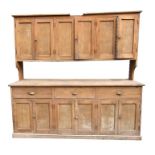 A large reclaimed pine dresser, the upper section with an arrangement of cupboards with panelled