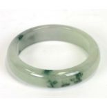 A jadeite / figured green hardstone bangle, 8cms diameter.