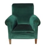 An Edwardian dark green upholstered armchair on square tapering front supports.