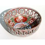 A Japanese Imari bowl decorated with phoenix and shishi, with a pierced rim, 15cms diameter.