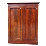 A Victorian figured mahogany wardrobe, the pair of doors enclosing hanging space and drawers.