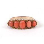 A Victorian yellow metal hoop ring set with five salmon coral graduated cabochons, weight 4.8g.