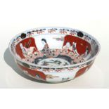 A Japanese Imari bowl decorated with a dragon and figures, 24cms diameter.