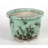 A Chinese celadon glazed planter decorated with flowers and calligraphy, 13cms high.
