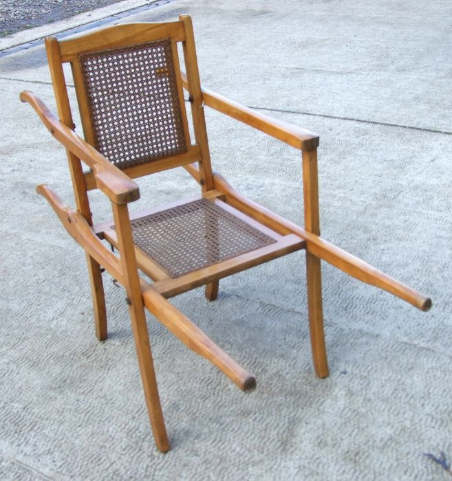 A teak sedan type chair with bergere cane back and seat.