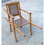 A teak sedan type chair with bergere cane back and seat.