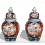 A pair of Japanese Imari temple jars and covers, 24cms high (2).