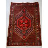 A Persian Hamadan woollen hand knotted rug with central gul within borders, 96 by 140 37.5 by