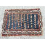 A Persian Hamadan rug with repeating floral motifs on a blue ground within a multi border, 87 by
