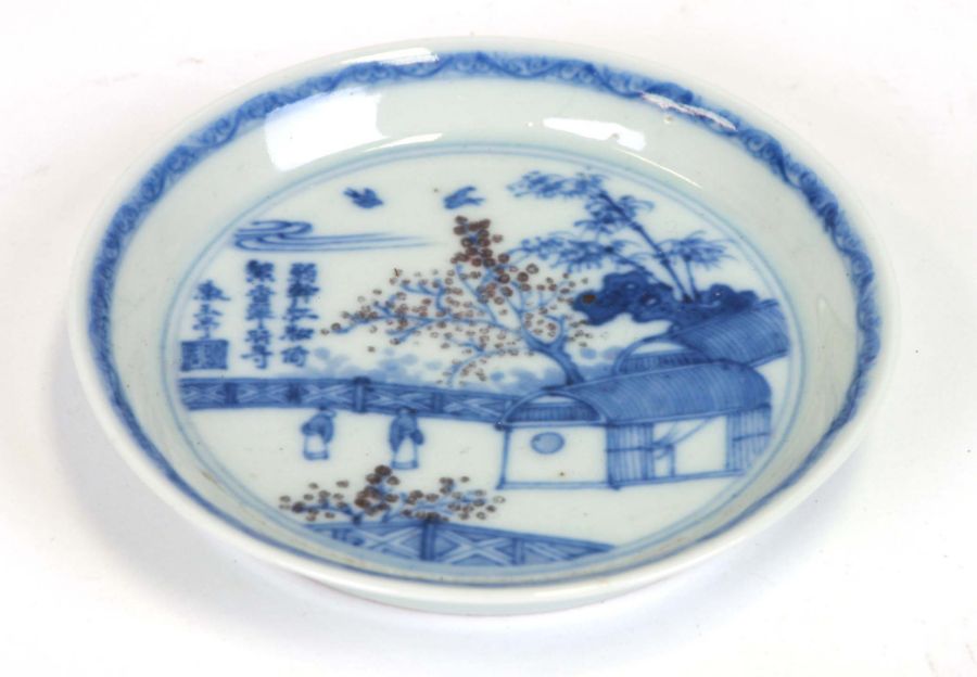 A Chinese blue & white shallow dish decorated with figures in a garden with calligraphy, eight