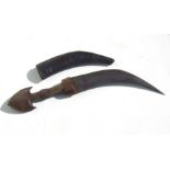 A Middle Eastern carved horn handled dagger in a leather scabbard, 40cms long.