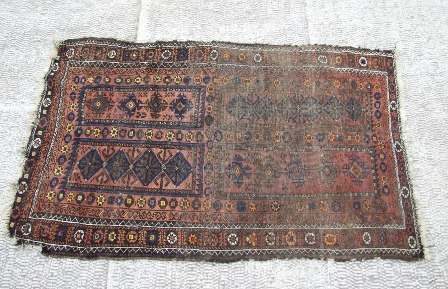 A Caucasian Shirvan rug with repeated geometric pattern on a brown ground, 102 by 170cms.