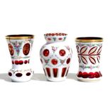 Three Bohemian white cased cranberry glasses with enamelled flowered decoration and gilding, 13cms
