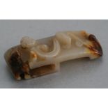 A Chinese figured jade / hardstone belt hook with carved chilong decoration, 7cms long.