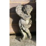 A well weathered reconstituted stone figure of a cherub, 69cms high.