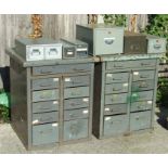 A pair of industrial metal cabinets, each with a wooden top above an arrangement of eleven