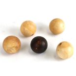 A group of 19th century ivory billiard balls, four natural and one stained, each approx 4.5cms
