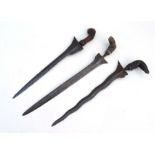 Three Indonesian Kris daggers without scabbards. Blade lengths are 36cms (14.125ins), 39cms (15.