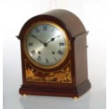 An early 20th century mantle clock, the silvered dial with Roman numerals, in a mahogany case with